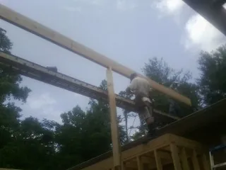Carpenter setting a ridge beam over a new addition frame — Ice Dam Removal by Roofing Brothers in Amory