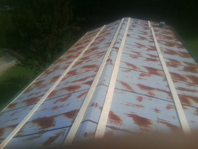 Rusted metal roof panels with new wood purlins before replacement — Storm Damage Roof Repair in Amory by Roofing Brothers