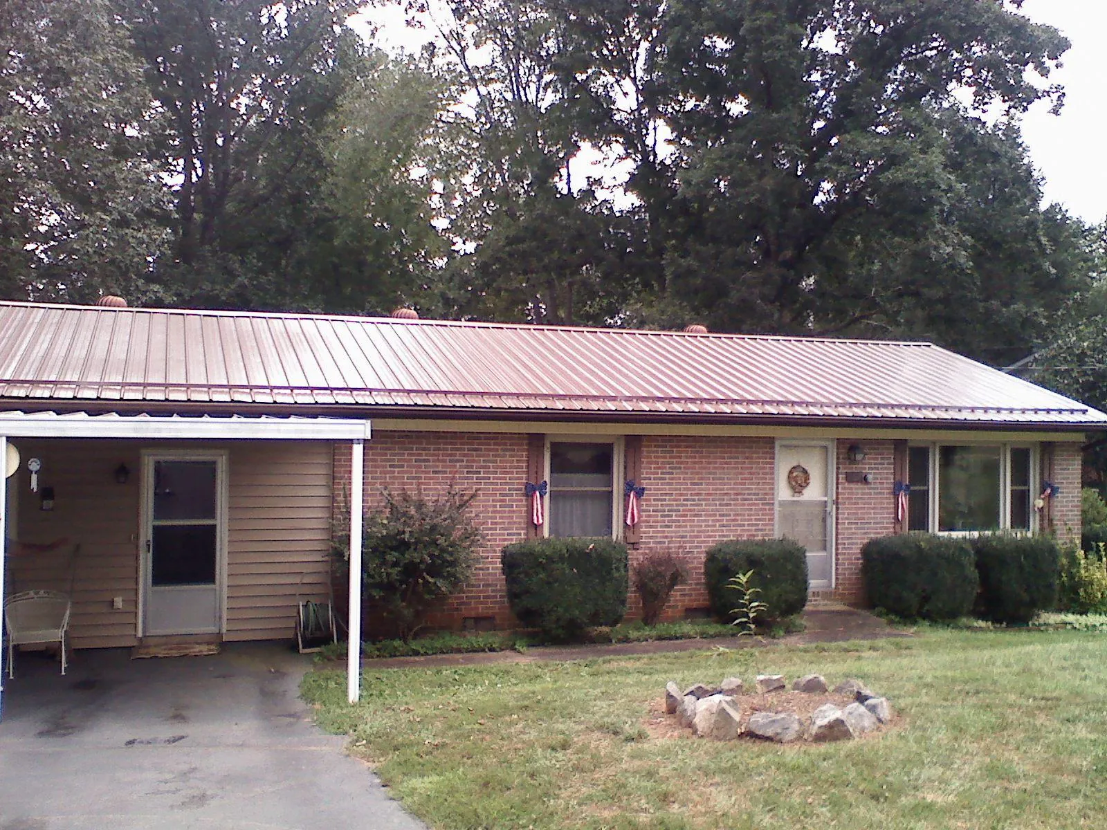 Bronze metal roof and carport on a brick ranch home — Roof Repair work by our crew in Amory